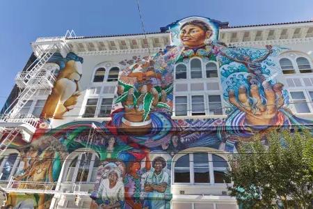 Un colorido mural a gran escala cubre el costado del Edificio de Mujeres en el 使命地区 de San Francisco.